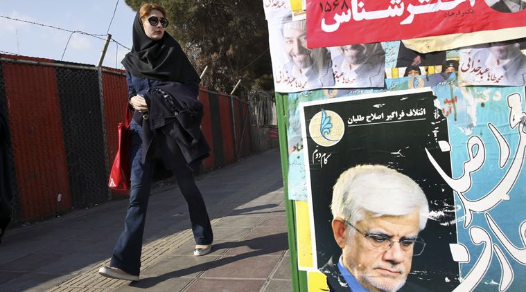 An Iranian woman walks past electoral posters of candidates of parliamentary elections in a sidewalk in Vanak square in northern Tehran, Iran, Thursday, Feb. 25, 2016. (Source: AP)