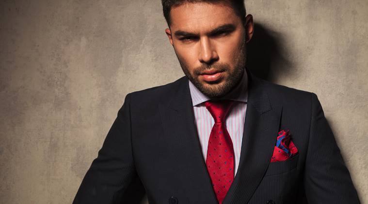 young business man leaning on a grey wall