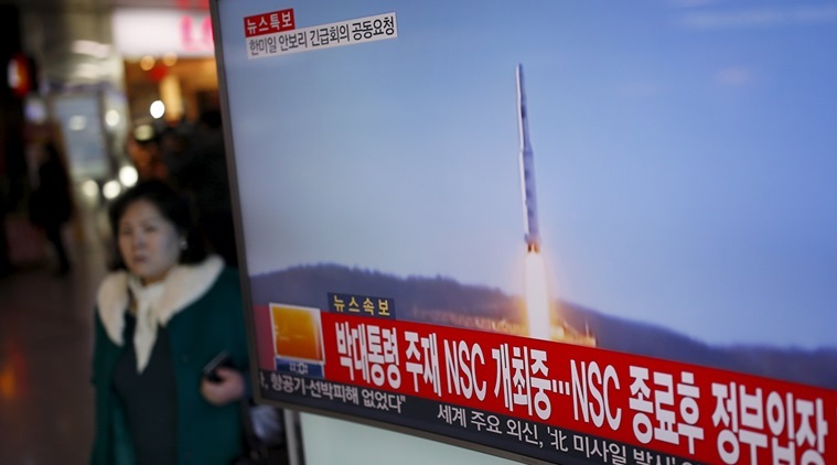 A passenger walks past a TV screen broadcasting a news report on North Korea's long range rocket launch at a railway station in Seoul, South Korea, February 7, 2016. REUTERS/Kim Hong-Ji