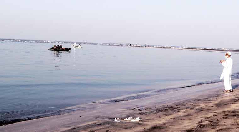 A man prays as rescuers try to locate bodies near Murud beach in Raigad, Maharashtra, on Tuesday. Narendra Vaskar