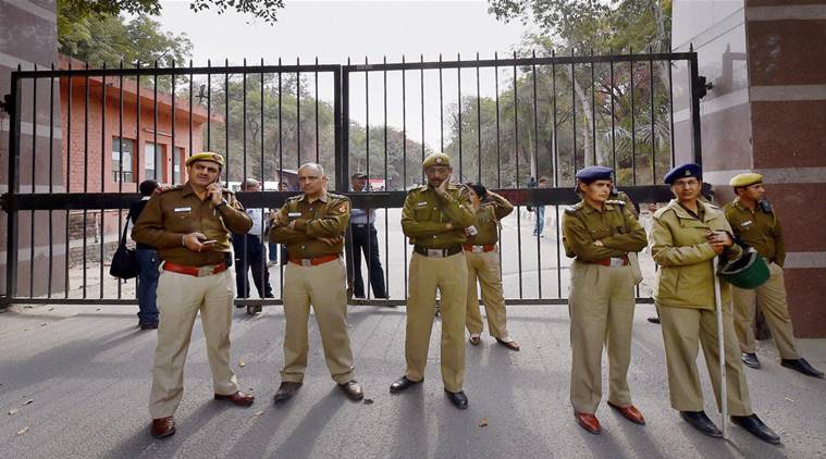 New Delhi: Police personnel guard at the entrance of JNU where students are agitating, in New Delhi on Monday. PTI Photo by Kamal Singh (PTI2_15_2016_000197B)