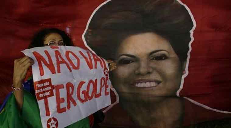 Woman shows poster written in Portuguese "There will not be a coup" next to a picture of Brazil's President Dilma Rousseff, during a rally in her support and of former President Luiz Inacio Lula da Silva, in Brasilia, Brazil. (Source: AP)