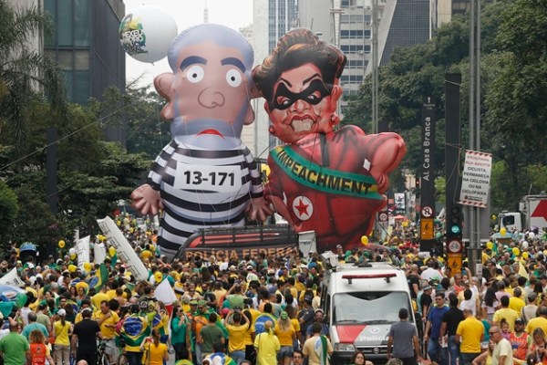Demonstrators parade large inflatable dolls depicting Brazil's former President Luiz Inacio Lula da Silva in prison garb and current President Dilma Rousseff dressed as a thief, with a presidential sash that reads "Impeachment," in Sao Paulo, Brazil, Sunday, March 13, 2016. The corruption scandal at the state-run oil giant Petrobras has ensnared key figures from Rousseffs Workers Party, including her predecessor and mentor, Lula da Silva, as well as members of opposition parties. (AP Photo/Andre Penner)