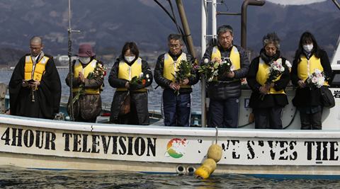 A monk accompanies people whose family members are still missing in the March 11, 2011 earthquake and tsunami offering prayers as Japanese Coast Guard divers conduct an underwater search Thursday, March 10, 2016, on the eve of the fifth anniversary of the deadly disaster, in Hirota Bay in Rikuzentakata, Iwate Prefecture, northeastern Japan. The Japanese coast guard has resumed underwater searches for some of the more than 2,500 people still missing from the 2011 disaster that devastated the countrys northeast coast. (AP Photo/Koji Ueda)