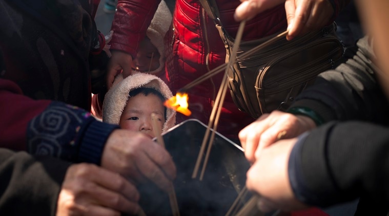 A child watches while relatives of passengers aboard missing Malaysia Airlines Flight 370 light incense sticks at the Lama Temple in Beijing, Tuesday, March 8, 2016. Tuesday marked the second anniversary of the disappearance of MH370, which vanished March 8, 2014 while en route from Kuala Lumpur to Beijing. (AP Photo/Mark Schiefelbein)