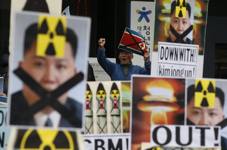 A South Korean man holding a crossed North Korean flag shouts slogans among placards with crossed portraits of North Korean leader Kim Jong Un pasted with the radiation warning symbol during an anti-North Korea rally in downtown Seoul. AP Photo