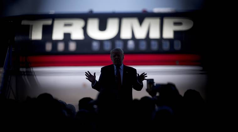 Republican presidential candidate Donald Trump is silhouetted against his plane as he speaks during a rally Saturday, Feb. 27, 2016, in Bentonville, Ark., as shot through the crowd. (AP Photo/John Bazemore)