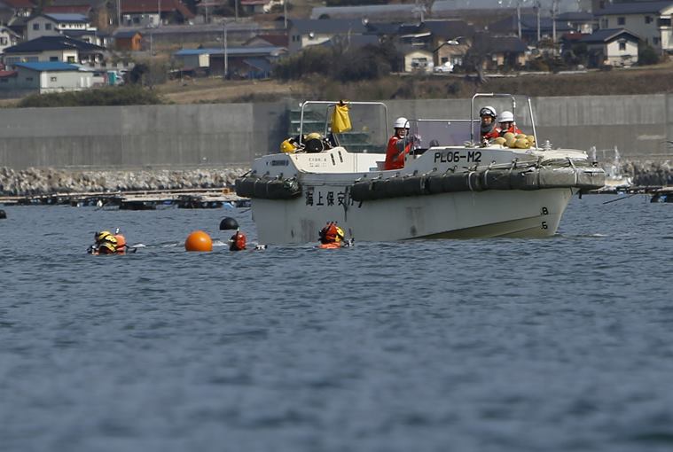 Japanese Coast Guard divers prepare for underwater searches Thursday, March 10, 2016, a day before the fifth anniversary of the deadly March 11, 2011 earthquake and tsunami, in Rikuzentakata, Iwate Prefecture, northeastern Japan. The Japanese coast guard has resumed underwater searches for some of the more than 2,500 people still missing from the 2011 disaster that devastated the countrys northeast coast. (AP Photo/Koji Ueda)