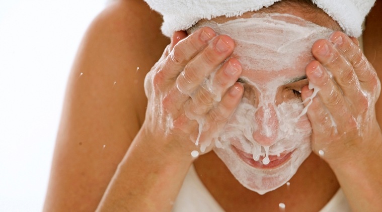 Close-up of a young woman splashing water on her face