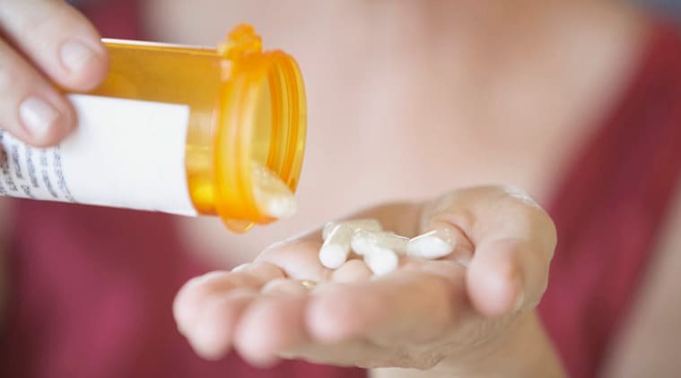 Close-up of a person's hands holding a bottle of pills