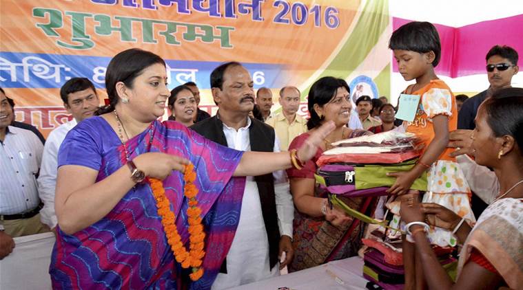 Ranchi: Union HRD Minister Smiriti Irani with Jharkhand Chief Minister Raghubar Das distributing school kits to tribal children during the launch of 'School Chale Hum Abhiyan' at a government school at Khunti district of Jharkhand on Friday. PTI Photo (PTI4_8_2016_000218A)