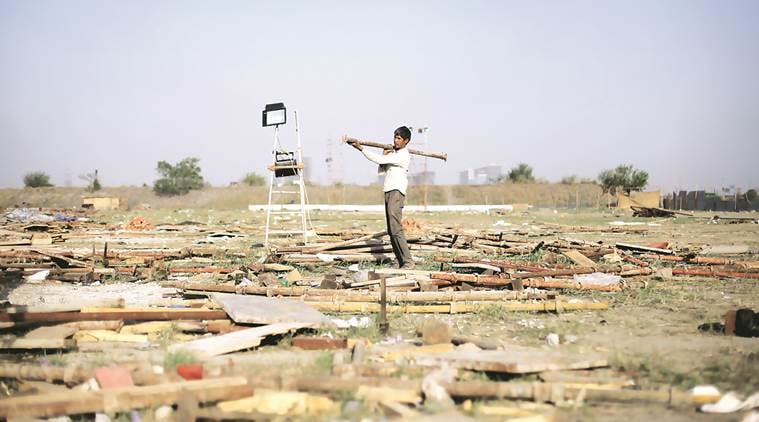Workers remove construction material from the site of the World Cultural Festival along the Yamuna Flood plains on Tuesday. Express photo by Oinam Anand. 12 April 2016