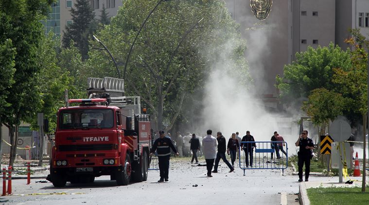 Security officers and firefighters work moments after an explosion outside the Police headquarters in Gaziantep, Turkey, Sunday, May 1, 2016. A car bomb struck the entrance of a Turkish police station Sunday in the southern city of Gaziantep, killing a policeman and injuring over 20 other people, an official said. (Depo Photos via AP) TURKEY OUT