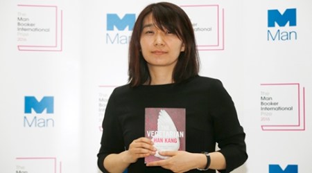 Winner of the 2016 Man Booker International prize for fiction Han Kang poses for the media with her book 'The Vegetarian' following the award ceremony in London, Monday, May, 16, 2016. (AP Photo/Alastair Grant)