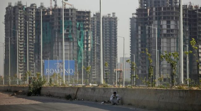An Indian buffalo herder sits in the shade of a road divider as his cattle graze in a field on the other side of the road on a hot afternoon in New Delhi, India, Wednesday, May 18, 2016. Scorching summer temperatures, hovering well over 40 degrees Celcius, (104 Fahrenheit) are making life extremely tough for millions of poor across north India. Without access to air conditioning and sometimes even an electric fan, they struggle to cope with the heat in their inadequate homes. (AP Photo/Altaf Qadri)