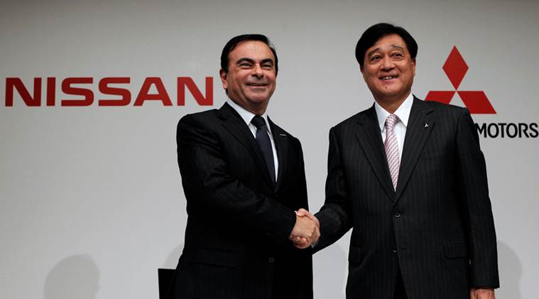 Nissan Motor's Chief Executive Carlos Ghosn (L) shakes hands with Mitsubishi Motors Corp.'s President Osamu Masuko at the end of their joint news conference in Tokyo December 14, 2010. REUTERS/Toru Hanai/File Photo TPX IMAGES OF THE DAY