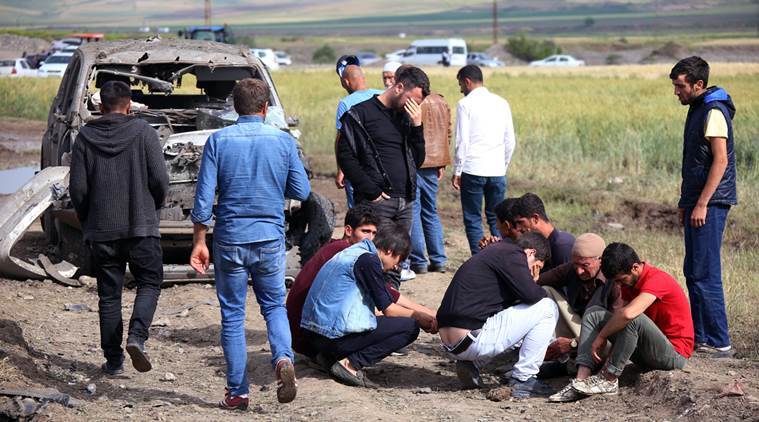 People react near Thursday's explosion site in Sarikamis district outside Diyarbakir, Turkey, Friday, May 13, 2016. A Turkish official said four Kurdish rebels were killed while loading explosives onto a truck in southeastern Turkey late Thursday, after a separate blast targeting the military in Istanbul wounded eight. (AP Photo/Mahmut Bozarslan)