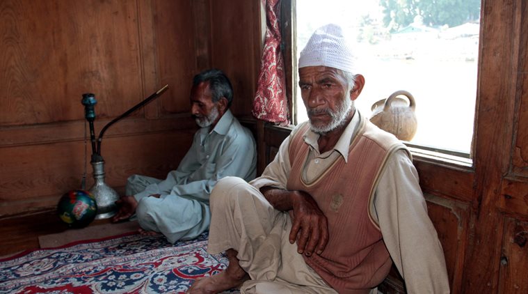 Relatives of Ghulam Muhammad Guroo mourning at his houseboat near Rajbagh. The 60-year-old boatman drowned in Jhelum river in Srinagar while saving three tourists after the Shikara they were riding capsized last week. Express Photo by Shuaib Masoodi 14-06-2016