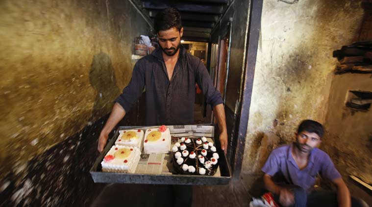 A Kashmiri baker walks with a tray of pastries for sale ahead of Eid al-Fitr in Srinagar, Indian controlled Kashmir Tuesday, July 5, 2016. (AP Photo)