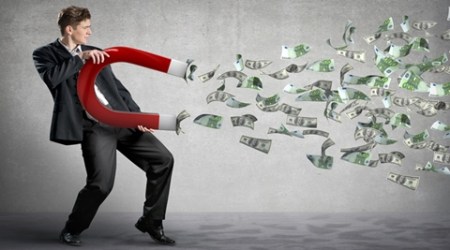 Businessman attracts money with a large magnet