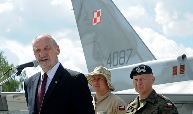 Polish Defense Minister Antoni Macierewicz speaks in front of a Polish Air Force F-16 fighter jet during a farewell ceremony of Polish soldiers leaving for Kuwait to take part in the operation Inherent Resolve , in Janow, Poland, Monday, July 4, 2016. During an interview Monday Macierewicz told The Associated Press that decisions to be approved at this week's NATO summit in Warsaw will build a force aimed at deterring any aggressive intentions by Russia against the West. (AP Photo/Alik Keplicz)