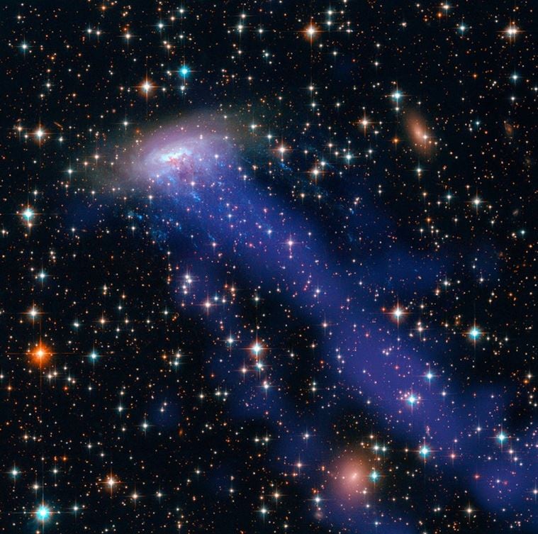 ESO 137-001 is a perfect example of a spiral galaxy zipping through a crammed cluster of galaxies. Gas is being pulled from its disc in a process called ram pressure stripping. The galaxy appears to be losing gas as it plunges through the Norma galaxy cluster. Image credit: NASA, ESA, and the Hubble Heritage Team. 