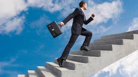 Image of confident businessman with briefcase walking upstairs