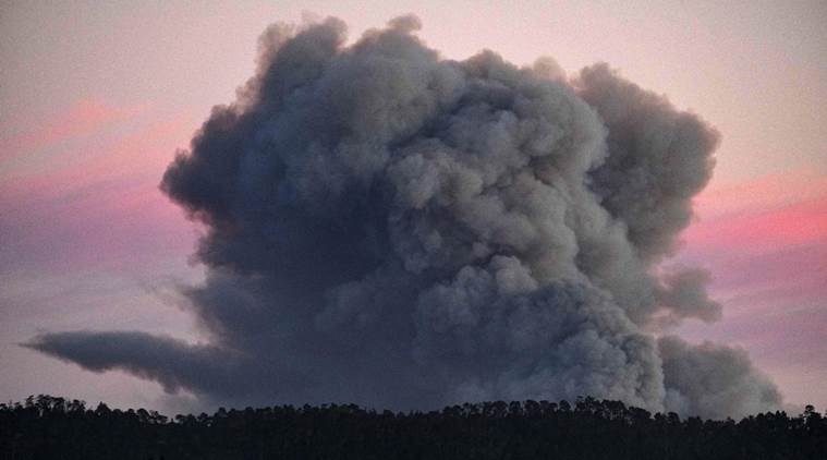 A large plume of smoke from a wildfire rises near Highway 1, burning five miles south of Carmel, Calif., on Friday, July 22, 2016. (AP Photo/Richard Vogel)