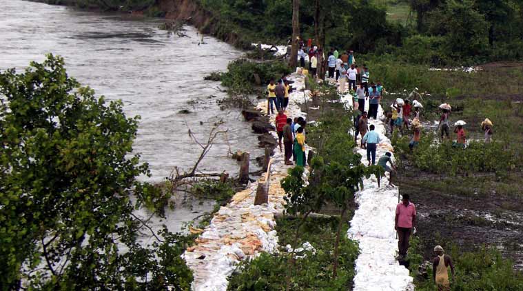 Villagers repairing the embankment of a river voluntarily to protect their villages from flood water at Narayanguri near Manas National Park in Baksa district of Assam on Thursday. (Source: PTI)