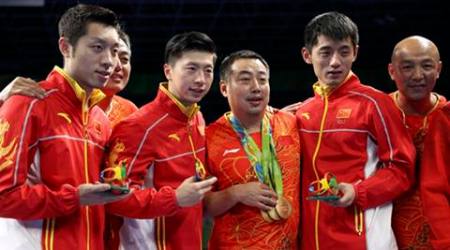 2016 Rio Olympics - Table Tennis - Men's Team - Victory Ceremony - Riocentro - Pavilion 3 - Rio de Janeiro, Brazil - 17/08/2016. Gold medallists Ma Long (CHN) of China, Xu Xin (CHN) of China and Zhang Jike (CHN) of China pose with their coach Liu Guoliang and other members of their team on the podium.            REUTERS/Alkis Konstantinidis FOR EDITORIAL USE ONLY. NOT FOR SALE FOR MARKETING OR ADVERTISING CAMPAIGNS.