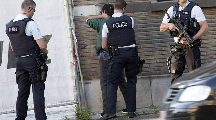 Police officers check the identification of a man near the police headquarters in Charleroi, Belgium on Saturday, Aug. 6, 2016. Ôªø Two female officers were attacked and wounded by a man wielding a machete and shouting "Allahu Akhbar" outside a police station in the Belgian city of Charleroi on Saturday, police said. (AP Photo/Virginia Mayo)