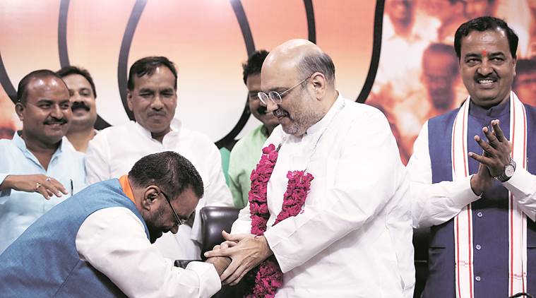 BJP president Amit Shah greets Swami Prasad Maurya as he joins the party in New Delhi on Monday. UP BJP chief  Keshav Prasad Maurya looks on. Express Photo by Tashi Tobgyal 