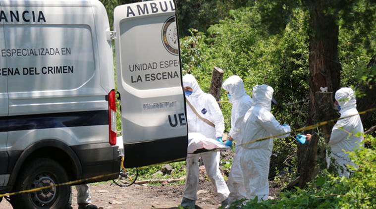 Forensic technicians carry a covered body at a crime scene where nine people were found dead in the municipality of Cuitzeo, in Mexico's western state of Michoacan July 30, 2016. REUTERS/Fernando Maldonado FOR EDITORIAL USE ONLY. NO RESALES. NO ARCHIVES.