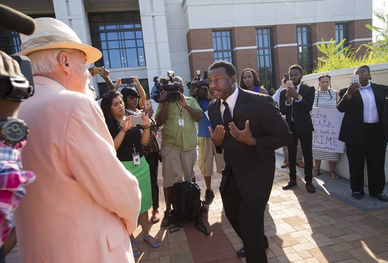Earl Lewis, cousin of William Chapman II, right, gestures during a heated discussion with Bill Garrett with the Chesapeake Citizens Police Academy Alumni Association in front of the Portsmouth Judicial Center Wednesday morning, July 27, 2016, Portsmouth, Va. Wednesday is the first day of trial for ex-Portsmouth police officer Stephen Rankin who is charged with first degree murder in the shooting death of William Chapman II last year in a Wal-Mart parking lot in Portsmouth. (Bill Tiernan/The Virginian-Pilot via AP)