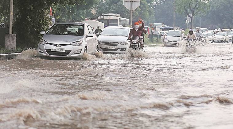 Commuters crossing flooded road near housing board lightpoint in Manimajra due to heavy rain on Thursday in Chandigarh, August 04 2016. Express Photo by Kamleshwar Singh