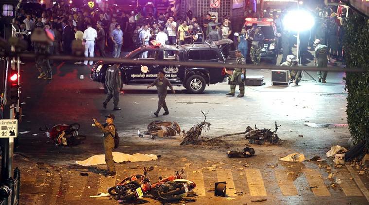 FILE - In this Aug. 17, 2015 file photo, a policeman photographs debris from an explosion in central Bangkok, Thailand. A Thai military court on Tuesday, Aug. 23, 2016 began the trial of two foreigners charged with the bombing of a popular shrine in Bangkok's center a year ago that killed 20 people and injured more than 120. (AP Photo/Mark Baker, File)
