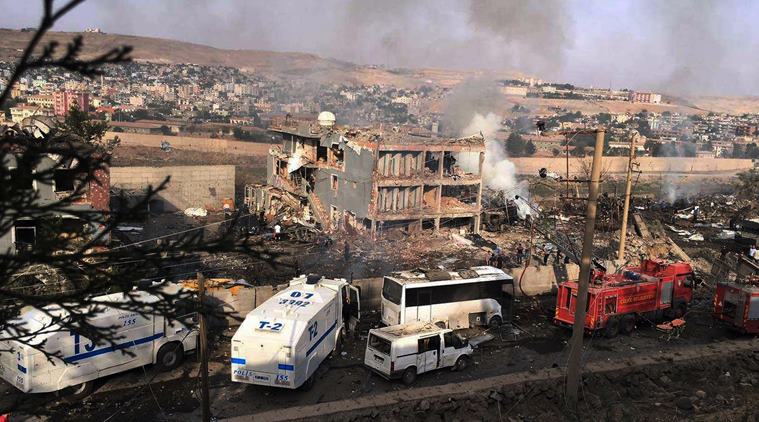 Smoke still rises from the scene after Kurdish militants attacked a police checkpoint in Cizre, southeast Turkey, Friday, Aug. 26, 2016, with an explosives-laden truck, killing several police officers and wounding dozens more, according to reports from the state-run Anadolu news agency. The attack struck the checkpoint some 50 meters (yards) from a main police station near the town of Cizre, in the mainly-Kurdish Sirnak province that borders Syria. Turkish authorities have put a temporary ban on distribution of images relating to Friday's Cizre attack within Turkey. (DHA via AP)
