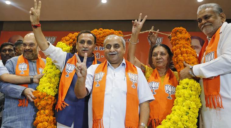 Vijay Rupani, second left, state president of Bharatiya Janata Party (BJP) in Gujarat, is garlanded as he is selected as Chief Minister of the state, along with Nitin Patel, third left, in Gandhinagar, India, Friday, Aug. 5, 2016. Patel will take over as Deputy Chief Minister. (AP Photo/Ajit Solanki)