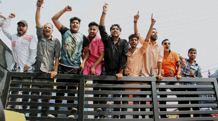 Activists of Bajrang Dal climb at the main gate of the Government Circuit House during a protest against the All Party Delegation (APD) for appeasing separatist elements in the Kashmir valley, in Jammu on Monday. PTI Photo