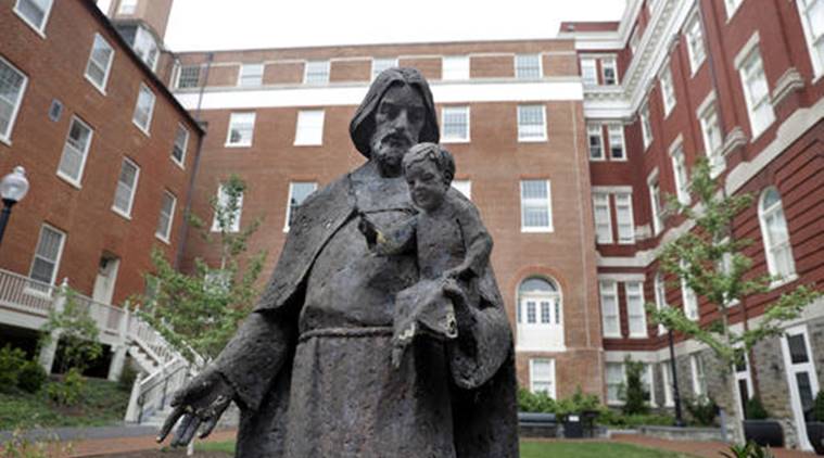 A Jesuit statue is seen in front of Freedom Hall, formerly named Mulledy Hall, on the Georgetown University campus, Thursday, Sept. 1, 2016, in Washington. After renaming the Mulledy and McSherry buildings at Georgetown University temporarily to Freedom Hall and Remembrance Hall, Georgetown University will give preference in admissions to the descendants of slaves owned by the Maryland Jesuits as part of its effort to atone for profiting from the sale of enslaved people. Georgetown president John DeGioia announced Thursday that the university will implement the admissions preferences. The university released a report calling on its leaders to offer a formal apology for the university's participation in the slave trade. (AP Photo/Jacquelyn Martin)