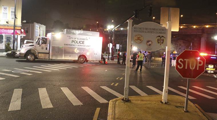Bomb squad personnel stand around the scene of an explosion near the train station, early Monday, Sept 19, 2016, in Elizabeth, N.J. A suspicious device found Sunday night in a trash can near a New Jersey train station exploded early Monday as a bomb squad robot attempted to disarm it. (Jessica Remo/NJ Advance Media via AP)