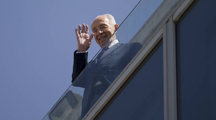 In this Tuesday, March 8, 2016. photo Former Israeli President Shimon Peres waves from his balcony before he meets Naomi Campbell in Tel Aviv, Israel. Shimon Peres, a former Israeli president and prime minister, whose life story mirrored that of the Jewish state and who was celebrated around the world as a Nobel prize-winning visionary who pushed his country toward peace, died early Wednesday, a person close to him confirmed. Peres was 93. (AP Photo/Ariel Schalit)