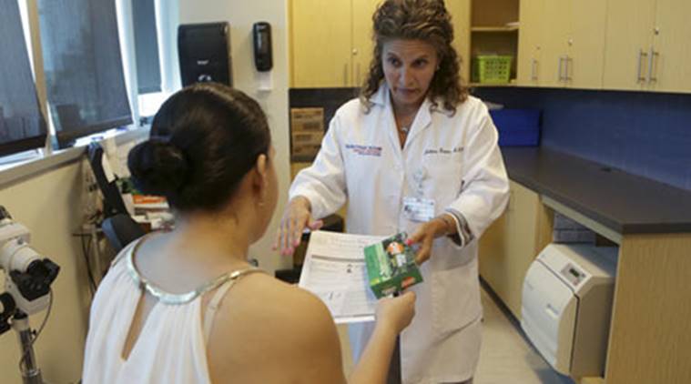 Nurse practitioner Juliana Duque, right, gives a patient, who is in her first trimester of pregnancy insecticide and and information about mosquito protection at the Borinquen Medical Center, Tuesday, Aug. 2, 2016 in Miami. The CDC has advised pregnant women to avoid travel to the nearby neighborhood of Wynwood where mosquitoes are apparently transmitting Zika directly to humans. The patient also had a test for the Zika virus following her exam. (AP Photo/Lynne Sladky)