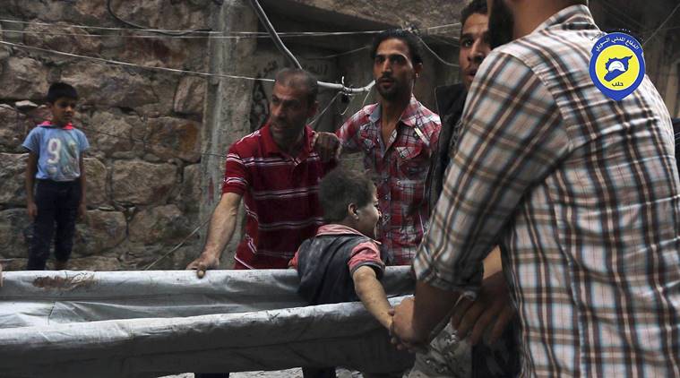 In this picture taken, Tuesday, Oct. 11, 2016, provided by the Syrian Civil Defense group known as the White Helmets, Syrian Civil Defense workers take out a boy, alive, from the rubble, in rebel-held eastern Aleppo, Syria. Activists and rescue workers say an intensive day of bombing on besieged rebel-held parts of Aleppo has left at least 25 people dead, including five children. The Britain-based Syrian Observatory for Human Rights says Wednesday that Tuesday's bombings killed 25 people. The Syrian Civil Defense, a team of first responders, and activist media platform Aleppo Media Center put the death toll at 41. (Syrian Civil Defense- White Helmets via AP)