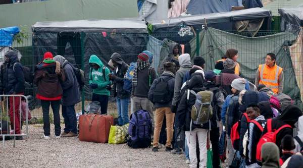 Migrants with their belongings queue at the start of their evacuation and transfer to reception centers in France, and the dismantlement of the camp called the "Jungle" in Calais, France, October 24, 2016.  REUTERS/Pascal Rossignol