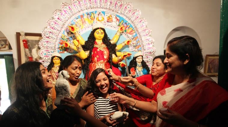 The homecoming: Family members crowd in front of the Durga idol at the Chatterjee home in Chorbagan. (Source: Express photo by Partha Paul)