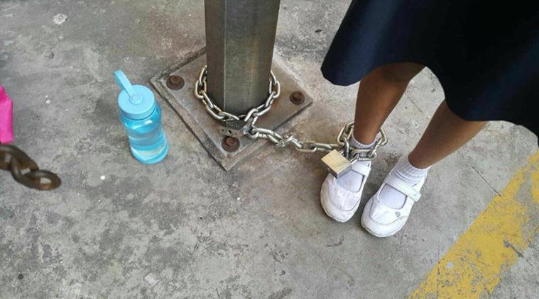mother chained girl, malaysia mother chained girl, girl chained to lamp post, girl chained to lamp post photos, parents children punishment, child assault, viral news, malaysia news, latest news, indian express