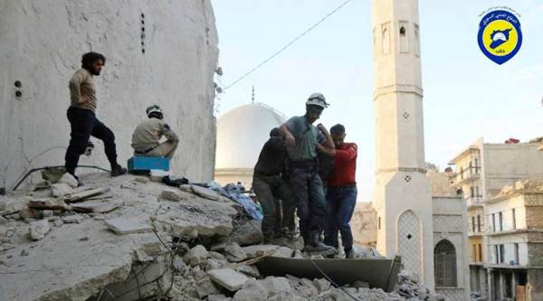 This Tuesday, Oct. 4, 2016 photo, provided by the Syrian Civil Defense group known as the White Helmets, shows Civil Defense workers from the White Helmets carry a body as they walk on the rubles of a destroyed building after airstrikes hit the Bustan al-Basha neighborhood in Aleppo, Syria. The U.N. on Wednesday released stark satellite images showing the most recent destruction of Syria's embattled northern city of Aleppo, pounded by Syrian and Russian airstrikes since the collapse of a U.S.-Russia brokered cease-fire two weeks ago. (Syrian Civil Defense White Helmets via AP)