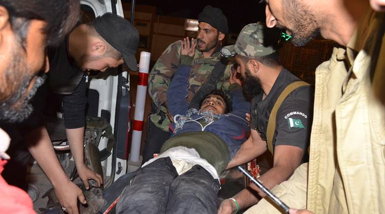 Pakistani volunteers and police officers rush an injured person to a hospital in Quetta, Pakistan, Monday, Oct. 24, 2016, after two separate attacks in Pakistan. Gunmen stormed a police training center in the restive southwestern province of Baluchistan Monday, leaving several people wounded, hours after another attack near to Quetta leaving two customs officers dead, authorities said. (AP Photo/Arshad Butt)