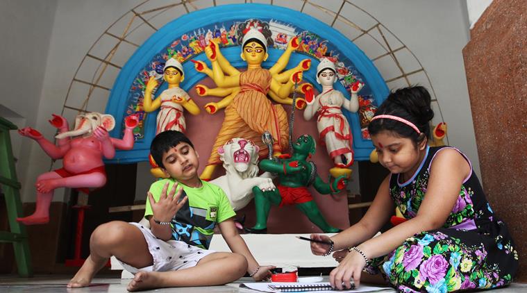 Young ones of the Daw family play in front of the Durga idol at their Jorasanko residence. (Source: Express photo by Partha Paul)